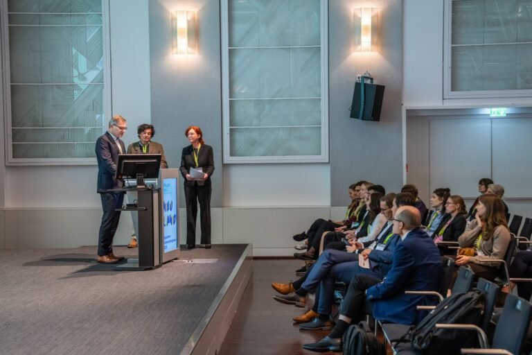 Referenten am Rednerpult bei einem Kongress, Publikum im Vordergrund